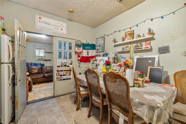 tiled dining area featuring a textured ceiling