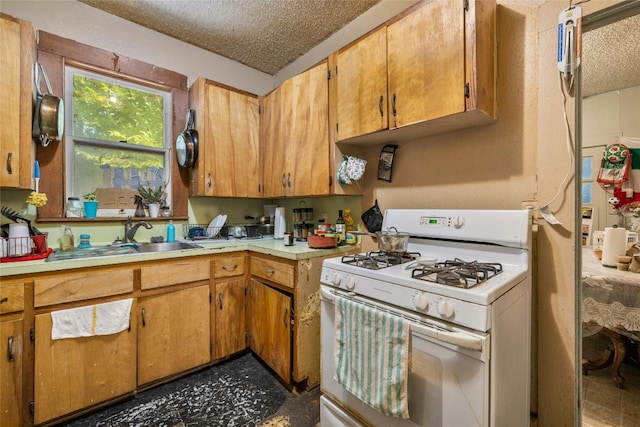 kitchen featuring sink, a textured ceiling, and white range with gas cooktop