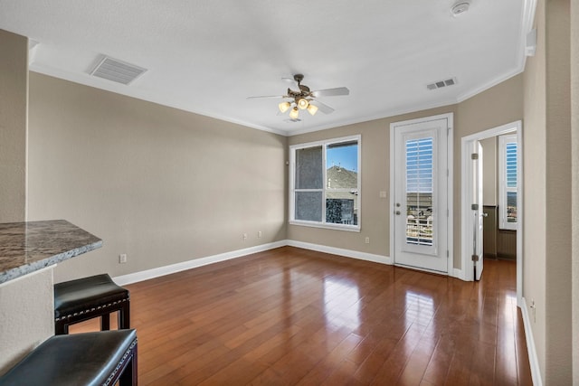 unfurnished living room featuring ceiling fan, crown molding, and dark hardwood / wood-style flooring