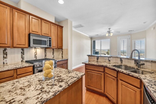 kitchen featuring light hardwood / wood-style flooring, stainless steel appliances, sink, and backsplash