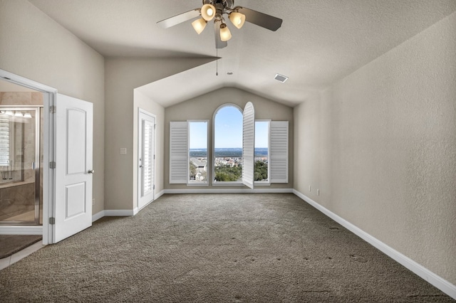 interior space featuring lofted ceiling, carpet flooring, ensuite bathroom, and ceiling fan