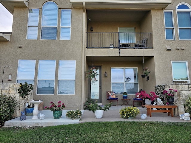 back of house featuring a yard and a balcony