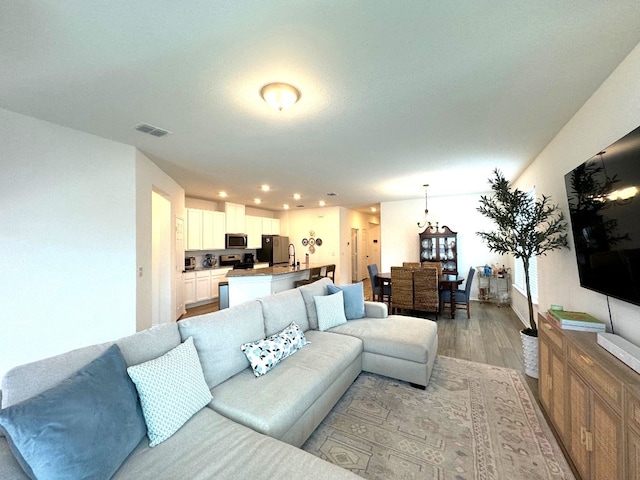 living room featuring a chandelier and light hardwood / wood-style floors