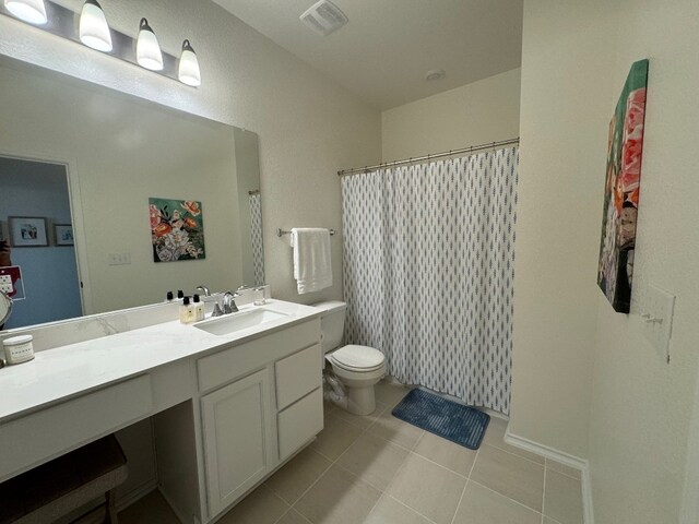 bathroom with toilet, tile patterned floors, and vanity