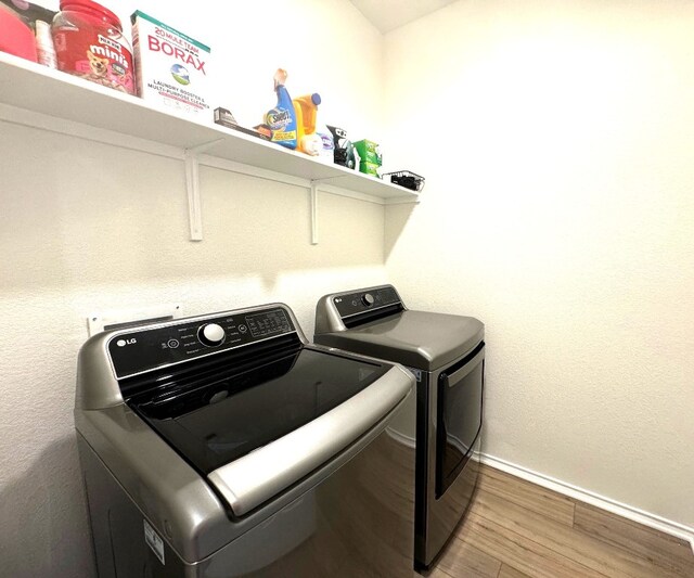 clothes washing area featuring hardwood / wood-style floors and independent washer and dryer