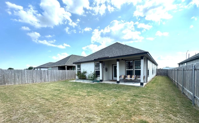 rear view of house with a patio and a lawn