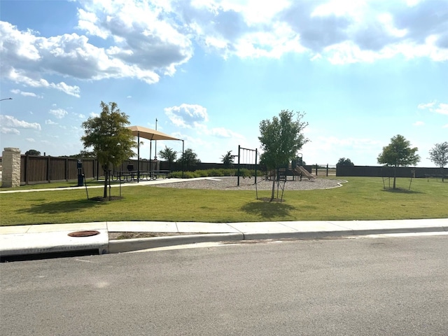 view of home's community with a playground and a lawn