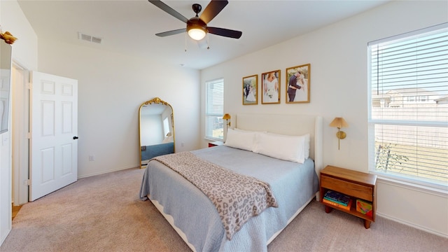 carpeted bedroom with ceiling fan and multiple windows