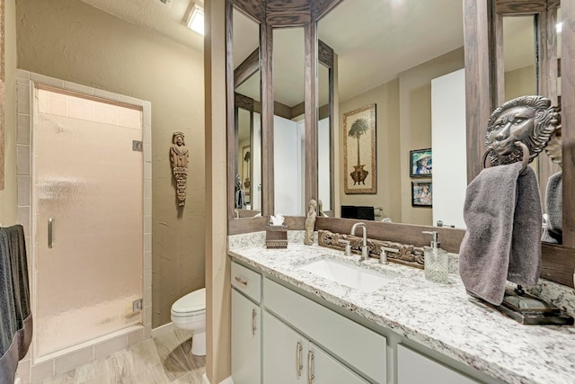 bathroom featuring vanity, toilet, and walk in shower