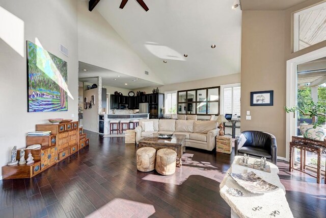 living room with beamed ceiling, ceiling fan, dark hardwood / wood-style floors, and high vaulted ceiling