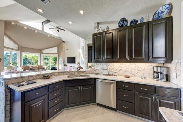 kitchen featuring sink, backsplash, dark brown cabinets, vaulted ceiling, and stainless steel dishwasher