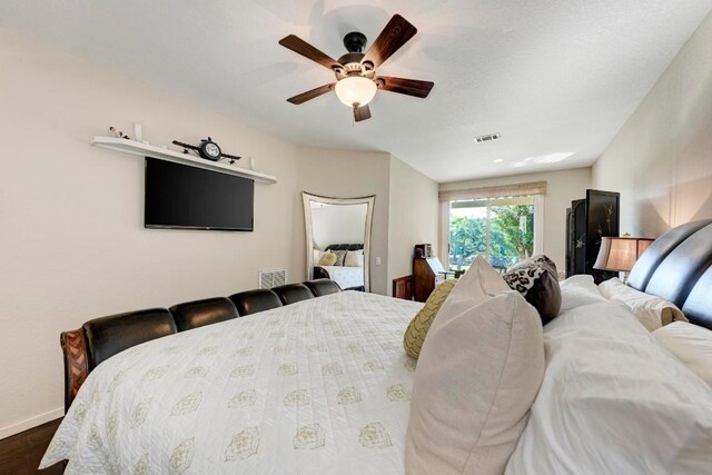 bedroom with dark hardwood / wood-style flooring and ceiling fan