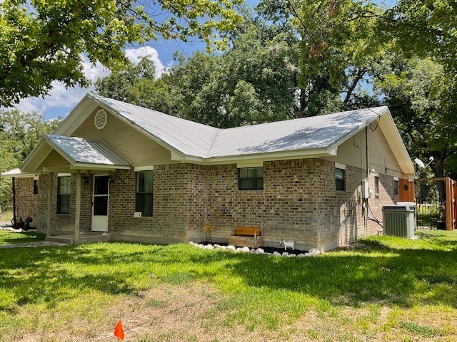 back of house featuring central AC and a yard