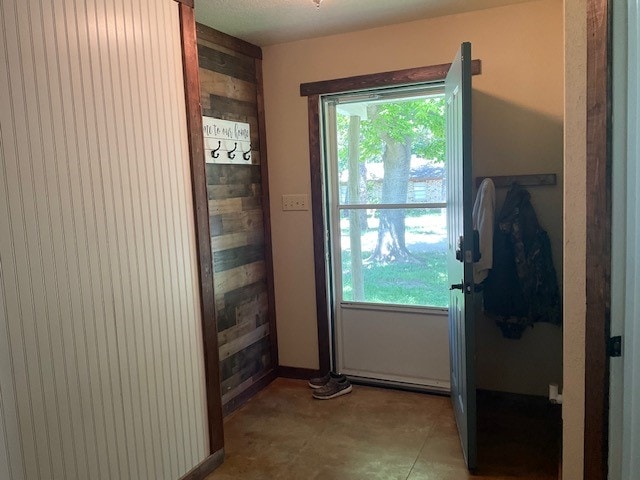 doorway to outside with wooden walls and a wealth of natural light