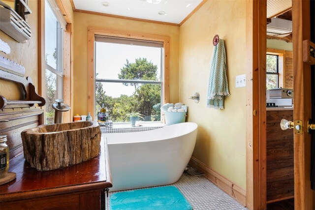 9000 Bear Creek Dr, Austin, TX 78737 - full bathroom with a freestanding tub, baseboards, ornamental molding, an AC wall unit, and tile patterned floors