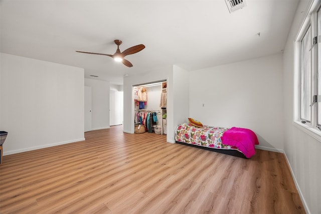 bedroom featuring multiple windows, light hardwood / wood-style floors, and a closet