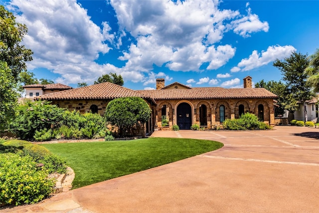 mediterranean / spanish house with a front lawn