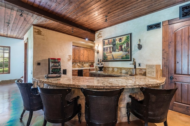 kitchen featuring backsplash, light stone counters, kitchen peninsula, and wood ceiling