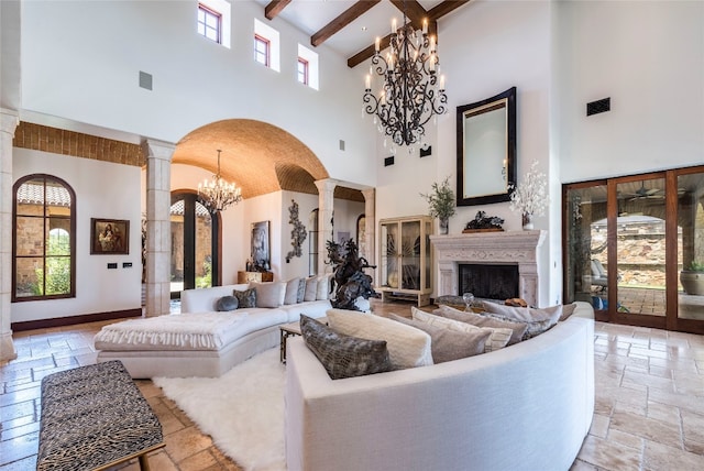 tiled living room featuring beam ceiling, high vaulted ceiling, ornate columns, and a chandelier