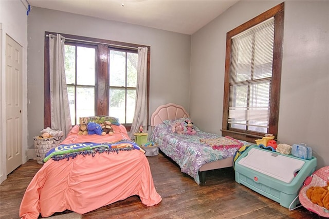 bedroom with dark wood-type flooring and multiple windows