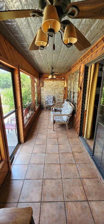 unfurnished sunroom with ceiling fan