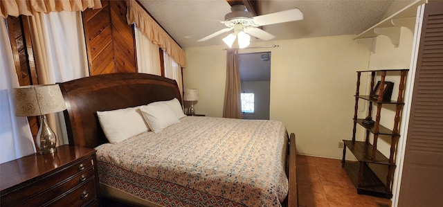 tiled bedroom with ceiling fan and a textured ceiling