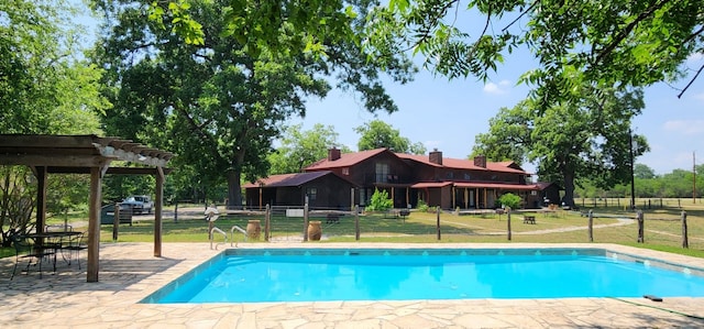 view of swimming pool featuring a pergola, a lawn, and a patio area