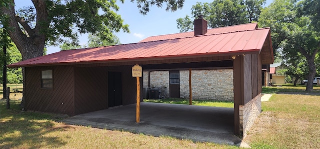 view of front of house featuring a front lawn, central AC, and a carport