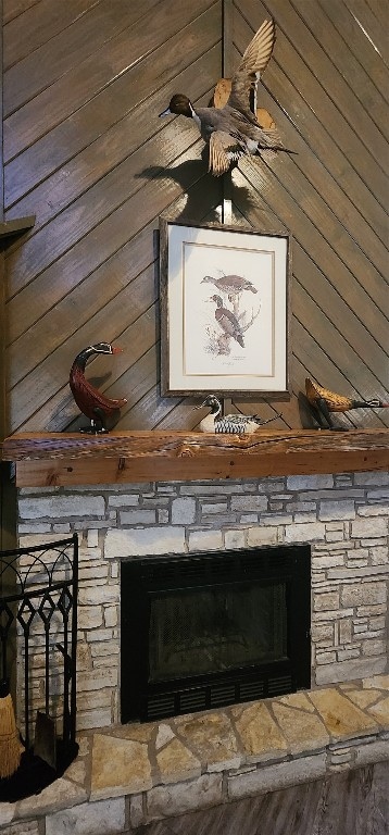 interior details featuring a fireplace and wooden walls