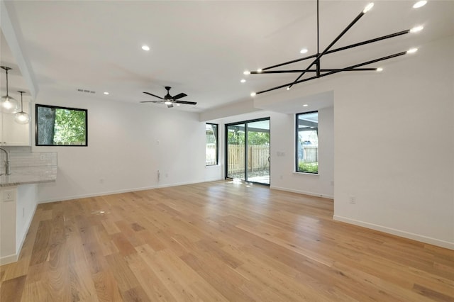 unfurnished living room with ceiling fan, light hardwood / wood-style flooring, and a wealth of natural light