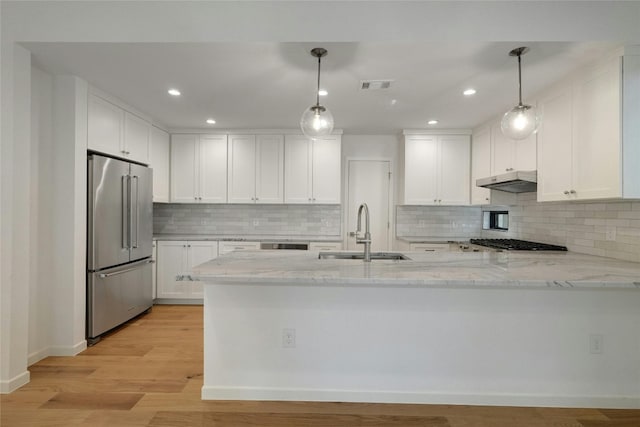 kitchen featuring light wood-type flooring, appliances with stainless steel finishes, pendant lighting, and sink