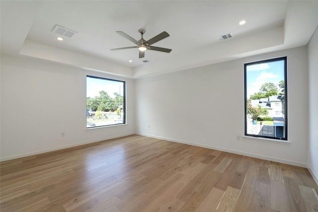 spare room featuring ceiling fan, a wealth of natural light, and light hardwood / wood-style floors