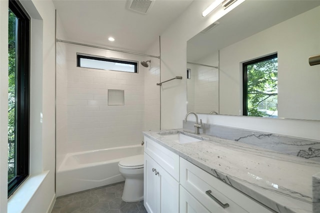 full bathroom featuring toilet, tile patterned floors, vanity, and tiled shower / bath