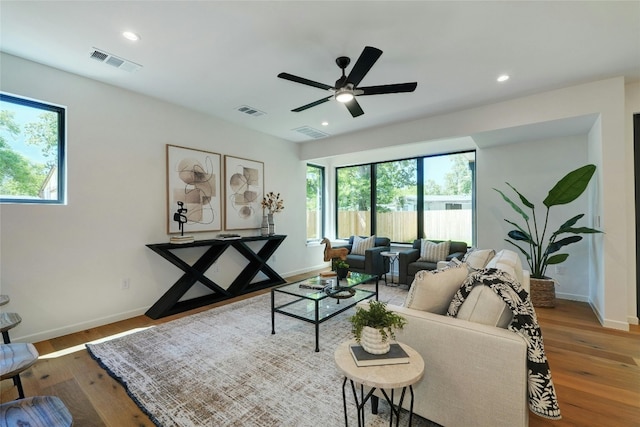 living room featuring ceiling fan and hardwood / wood-style flooring