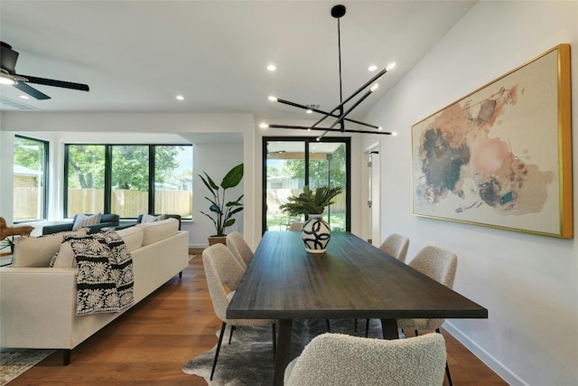 dining room featuring lofted ceiling, dark hardwood / wood-style flooring, and ceiling fan with notable chandelier