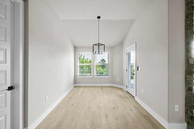 unfurnished dining area with a chandelier and light hardwood / wood-style flooring