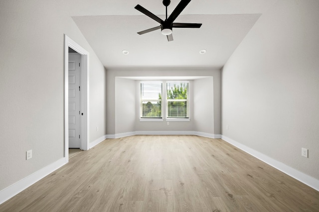 spare room with vaulted ceiling, ceiling fan, and light wood-type flooring