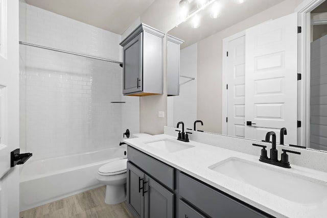 full bathroom with vanity, tiled shower / bath combo, and toilet