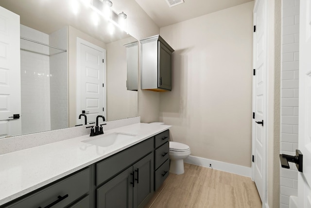 bathroom featuring vanity, hardwood / wood-style floors, and toilet