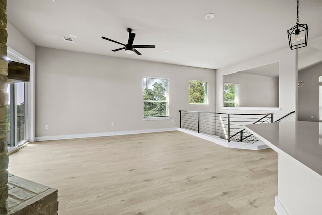 unfurnished living room featuring ceiling fan and light wood-type flooring