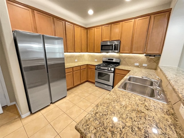 kitchen with light tile patterned floors, appliances with stainless steel finishes, sink, and backsplash