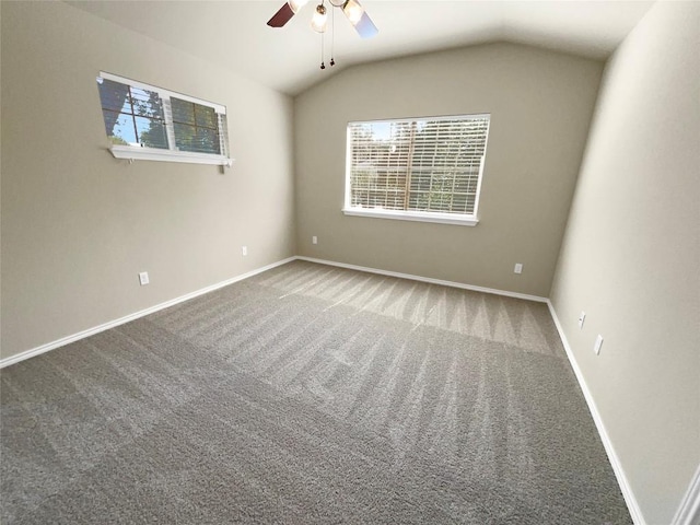 carpeted empty room featuring ceiling fan, plenty of natural light, and vaulted ceiling