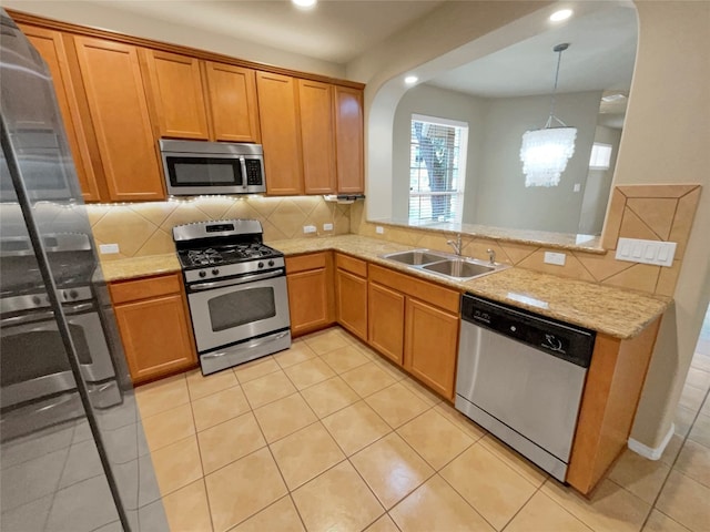 kitchen with kitchen peninsula, hanging light fixtures, backsplash, stainless steel appliances, and sink