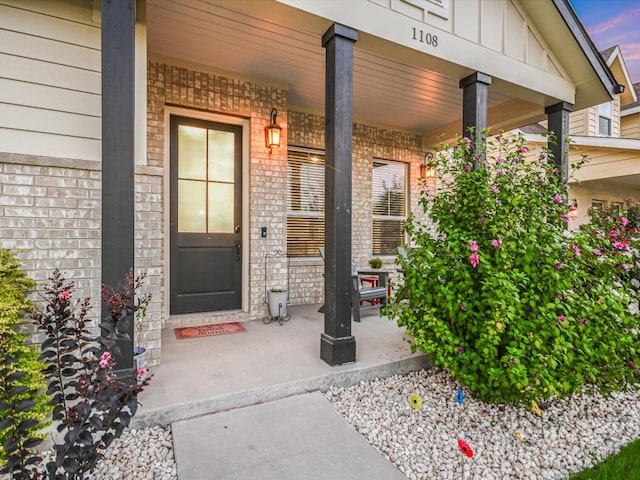 exterior entry at dusk featuring covered porch