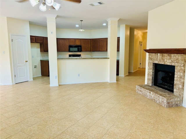 kitchen with kitchen peninsula, a brick fireplace, ceiling fan, range, and hanging light fixtures