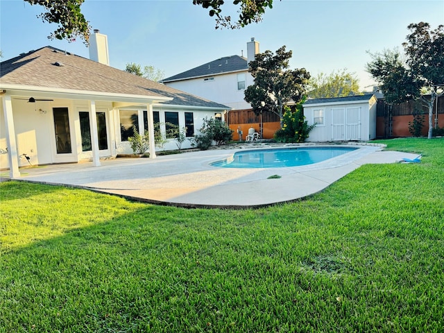 view of swimming pool featuring a yard, a patio, and a storage unit