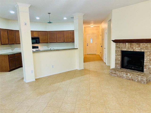 kitchen featuring range, pendant lighting, and a brick fireplace