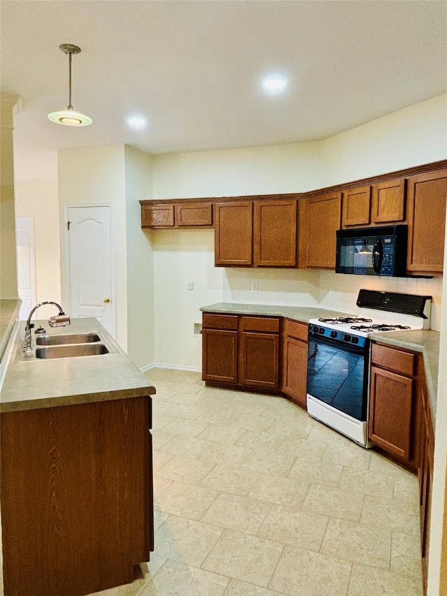 kitchen featuring backsplash, decorative light fixtures, white gas range, and sink