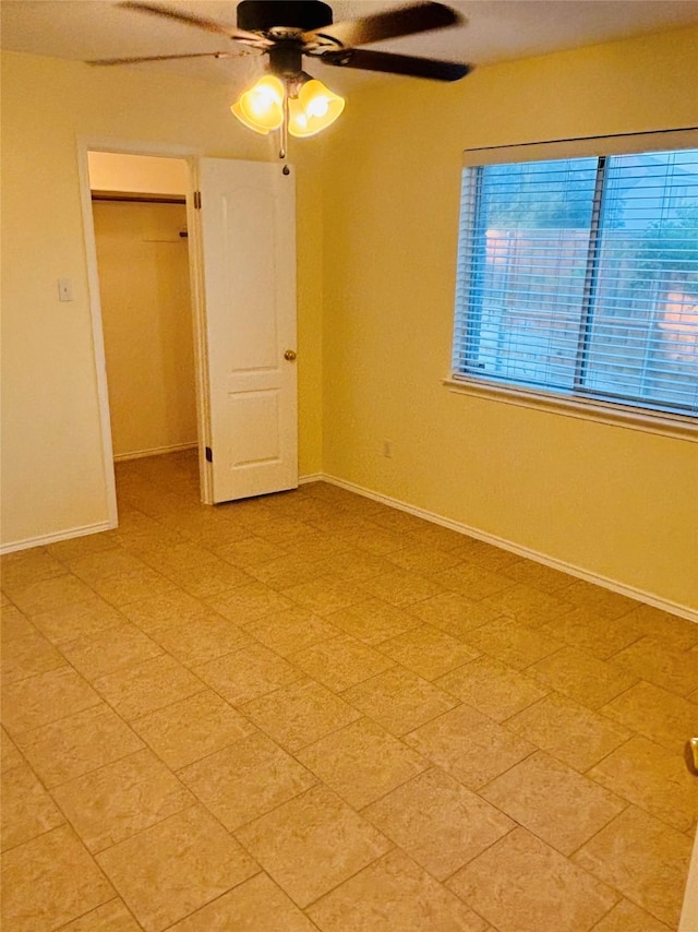 unfurnished bedroom featuring ceiling fan and a closet