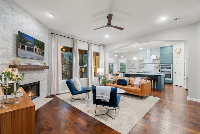 living room with ceiling fan, dark hardwood / wood-style floors, and a fireplace